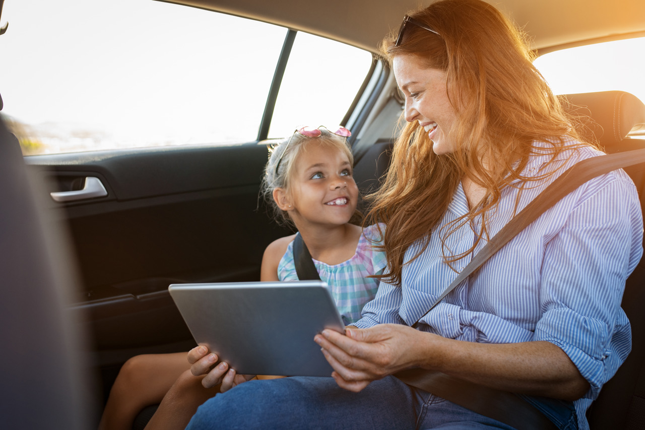 Mother and daughter riding together in the back seat of an Auckland taxi van